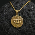 Load image into Gallery viewer, Gold plated Emperor Augustus coin pendant necklace photographed on porous black volcanic stone, emphasizing the imperial bust, laurel crown, and historical Latin inscription in a luxury jewelry composition.