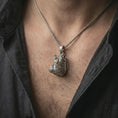 Load image into Gallery viewer, Oxidized hippo head pendant necklace worn on the chest, close-up lifestyle jewelry photo showing the animal charm on a spiga chain with dark clothing.