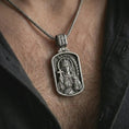 Load image into Gallery viewer, Oxidized Saint Barbara pendant necklace worn on the chest, close-up lifestyle jewelry photo showing the religious medallion on a spiga chain with dark clothing.