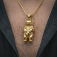 Load image into Gallery viewer, Gold plated baby bear pendant necklace worn on the chest, premium lifestyle jewelry photo with the cute bear cub pendant centered on a spiga chain.