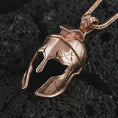 Load image into Gallery viewer, Rose gold plated Spartan helmet pendant necklace on textured volcanic rock, detailed macro product shot with soft warm reflections and bold ancient warrior styling.
