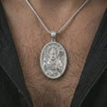 Load image into Gallery viewer, Polished silver Saint Patrick pendant necklace worn on the chest, masculine lifestyle shot highlighting the bishop relief, shamrock detail, and bright silver finish.