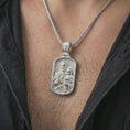 Load image into Gallery viewer, Polished silver Saint Joseph and Jesus pendant necklace worn on the chest, masculine lifestyle shot highlighting the father and child relief, lily detail, and bright silver finish.