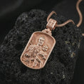 Load image into Gallery viewer, Rose gold plated Saint Joseph and Jesus pendant necklace on textured volcanic rock, detailed macro product shot with soft warm reflections and devotional father-and-child design.