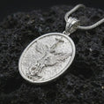 Load image into Gallery viewer, Polished silver Saint Michael pendant necklace on textured volcanic rock, centered macro jewelry photo with detailed archangel relief and bright silver highlights.