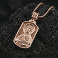 Load image into Gallery viewer, Rose gold plated Saint James the Apostle pendant necklace on textured volcanic rock, detailed macro product shot with soft warm reflections and devotional Saint James design.