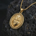 Load image into Gallery viewer, Gold plated Sacred Heart pendant necklace on textured volcanic rock, premium close-up studio composition emphasizing the flaming heart, cross, and crown of thorns symbolism.