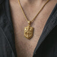 Load image into Gallery viewer, Gold plated knight shield pendant necklace worn on the chest, premium lifestyle jewelry photo with the medieval shield pendant centered on a spiga chain.