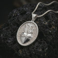 Load image into Gallery viewer, Polished silver Sacred Heart pendant necklace on textured volcanic rock, centered macro jewelry photo with detailed Catholic relief and bright silver highlights.