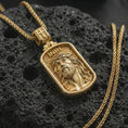 Load image into Gallery viewer, Gold plated INRI Jesus pendant necklace on textured volcanic rock, premium close-up studio composition emphasizing the Jesus face, crown of thorns, and rectangular medallion design.