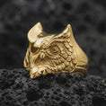 Load image into Gallery viewer, Gold plated owl ring captured on porous volcanic rock in the same close-up studio composition, highlighting the engraved feathers.