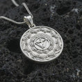 Load image into Gallery viewer, Polished silver Manipura chakra pendant necklace on textured volcanic rock, centered macro jewelry photo with detailed lotus mandala relief and bright silver highlights.
