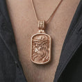 Load image into Gallery viewer, Rose gold plated crucified Jesus dog tag pendant necklace worn on the chest, close-up lifestyle shot featuring the sacred Jesus Christ design with warm rose gold tones.