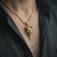 Load image into Gallery viewer, A gold plated oni mask pendant is worn on the neck in a close-up lifestyle shot, styled as a bold protective samurai-inspired necklace for men.