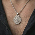 Load image into Gallery viewer, A polished silver Spartan warrior pendant is worn on the neck in a premium close-up lifestyle image, showing the Greek soldier motif clearly.