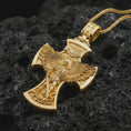 Load image into Gallery viewer, Gold plated Saint Michael cross pendant necklace on textured volcanic rock, premium close-up studio composition emphasizing the winged archangel, cross frame, sword, and shield symbolism.