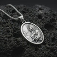 Load image into Gallery viewer, Polished silver Jesus Christ prayer pendant necklace on textured volcanic rock, centered macro jewelry photo with detailed Christian relief and bright silver highlights.