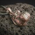 Load image into Gallery viewer, Bronze hippo head pendant necklace on textured volcanic rock, close-up studio shot highlighting the sculpted animal face, rounded muzzle, detailed eyes, and antique silver contrast.