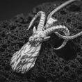 Load image into Gallery viewer, Polished silver ram horn pendant necklace on textured volcanic rock, centered macro jewelry photo with detailed Aries talisman sculpting and bright silver highlights.