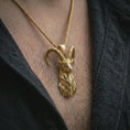 Load image into Gallery viewer, Gold plated ram horn pendant necklace worn on the chest, premium lifestyle jewelry photo with the mythic goat pendant centered on a spiga chain.