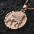 Load image into Gallery viewer, Rose gold plated Assyrian Lamassu pendant necklace on textured volcanic rock, detailed macro product shot with soft warm reflections and historic Mesopotamian design.