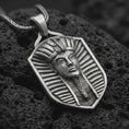 Load image into Gallery viewer, Oxidized pharaoh shield pendant necklace on textured volcanic rock, close-up studio shot highlighting the Egyptian king portrait, royal headdress, shield frame, and antique silver contrast.