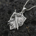 Load image into Gallery viewer, Polished silver knight and shield pendant on textured volcanic stone, macro close-up with premium studio lighting.