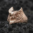 Load image into Gallery viewer, Rose gold plated owl ring photographed on volcanic rock with a luxury macro look, showing the owl’s intense gaze.