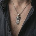 Load image into Gallery viewer, An oxidized Taurus bull pendant is worn on the neck in a close-up lifestyle shot, centered on the chest as a masculine zodiac amulet.