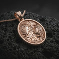 Load image into Gallery viewer, A rose gold plated Gemini pendant is photographed on porous volcanic rock in a close-up studio composition with refined luxury lighting and soft sculptural detail.
