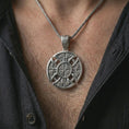 Load image into Gallery viewer, Polished silver Celtic cross pendant necklace worn on the chest, masculine lifestyle shot highlighting the bright silver finish, openwork cross shape, and detailed Celtic knots.