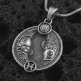 Load image into Gallery viewer, Oxidized Pisces zodiac pendant necklace on textured volcanic rock, close-up studio shot highlighting the twin fish, sun detail, Pisces symbol, and antique silver contrast.