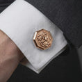 Load image into Gallery viewer, A rose gold plated Medusa cufflink is worn on a shirt cuff in a close-up lifestyle composition, highlighting its octagon frame and mythological design.