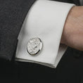 Load image into Gallery viewer, Polished silver Saint Michael cufflinks worn on a suit cuff, masculine formalwear shot highlighting the bright silver finish, oval frame, and archangel relief.