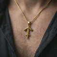 Load image into Gallery viewer, A gold plated Tyr rune pendant is worn on the neck in a close-up lifestyle shot, styled as a powerful Viking symbol gift for men.