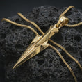 Load image into Gallery viewer, A gold plated Gungnir pendant lies on textured volcanic rock in a dramatic studio macro shot, highlighting the Spear of Odin motif and Viking-inspired form.