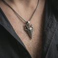 Load image into Gallery viewer, An oxidized Freyja cat pendant is worn on the neck in a close-up lifestyle shot, centered on the chest as a meaningful Norse mythology necklace.