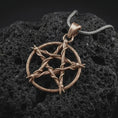 Load image into Gallery viewer, Bronze thorn pentagram pendant necklace on textured volcanic rock, close-up studio shot highlighting the woven thorn circle, five-point star shape, barbed details, and antique silver contrast.