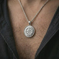 Load image into Gallery viewer, Polished silver Vegvisir Viking rune pendant necklace worn on the chest, masculine lifestyle shot highlighting the bright silver finish, rune details, and compass symbol.