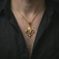 Load image into Gallery viewer, Gold plated fleur-de-lis pendant necklace worn on the chest, premium lifestyle jewelry photo with the royal Gothic pendant centered on a spiga chain.