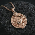 Load image into Gallery viewer, Rose gold plated Cancer zodiac pendant necklace on textured volcanic rock, detailed macro product shot with soft warm reflections and symbolic zodiac styling.