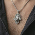 Load image into Gallery viewer, Polished silver hamsa elephant pendant necklace worn on the chest, spiritual lifestyle shot highlighting the bright silver finish, elephant face relief, and third eye detail.