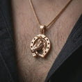 Load image into Gallery viewer, Rose gold plated horseshoe pendant necklace worn on the chest, close-up lifestyle shot featuring the lucky horseshoe design with warm rose gold tones.