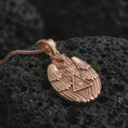 Load image into Gallery viewer, Rose gold plated owl all-seeing eye pendant necklace on textured volcanic rock, detailed macro product shot with soft warm reflections and symbolic owl protection styling.