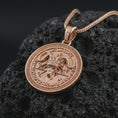 Load image into Gallery viewer, Rose gold plated Baphomet pendant necklace on textured volcanic rock, detailed macro product shot with soft warm reflections and gothic ritual symbolism.