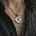 Load image into Gallery viewer, Polished silver Capricorn zodiac pendant necklace worn on the chest, masculine lifestyle shot highlighting the sea goat relief, sun detail, and bright silver finish.