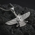 Load image into Gallery viewer, Polished silver Faravahar pendant necklace on textured volcanic rock, centered macro jewelry photo with detailed Ahura Mazda-inspired relief and bright silver highlights.