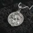 Load image into Gallery viewer, Polished silver Virgo zodiac pendant necklace on textured volcanic rock, centered macro jewelry photo with detailed horoscope figure relief and bright silver highlights.