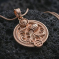 Load image into Gallery viewer, Rose gold plated Aquarius zodiac pendant necklace on textured volcanic rock, detailed macro product shot with soft warm reflections and symbolic zodiac styling.