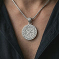 Load image into Gallery viewer, Polished silver Vegvisir Viking compass pendant necklace worn on the chest, masculine lifestyle shot highlighting the runic compass design, Celtic knot border, and bright silver finish.